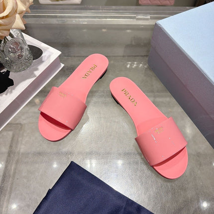 PRADA 26S LOGO EMBOSSED SLIDE SANDALS IN PINK PATENT CALFSKIN
