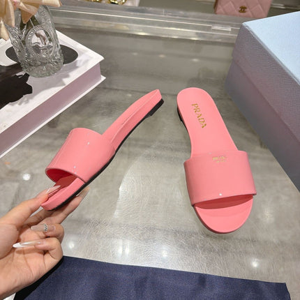 PRADA 26S LOGO EMBOSSED SLIDE SANDALS IN PINK PATENT CALFSKIN