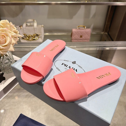 PRADA 26S LOGO EMBOSSED SLIDE SANDALS IN PINK PATENT CALFSKIN