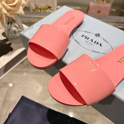 PRADA 26S LOGO EMBOSSED SLIDE SANDALS IN PINK PATENT CALFSKIN